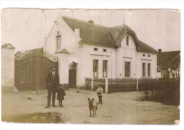 Dobová fotografie rodinné usedlosti v Radonicích s hospodářem, dětmi a psem